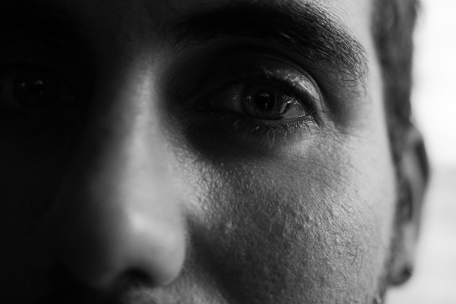 Close-up black and white shot focusing on a person's eye, highlighting texture and expression.