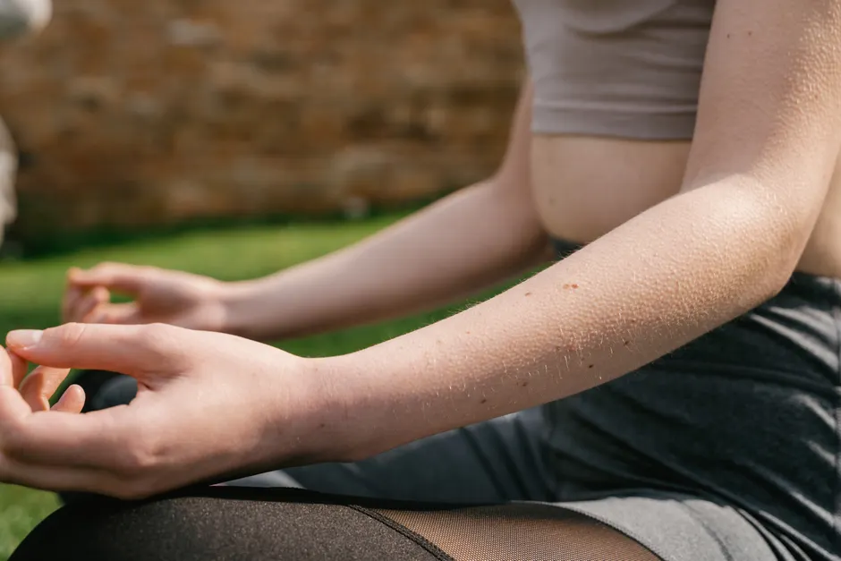 Pleine conscience et stress : les résultats des études de 2025 Close-up of a woman practicing yoga outdoors in the sunlight, focusing on mindfulness and relaxation.