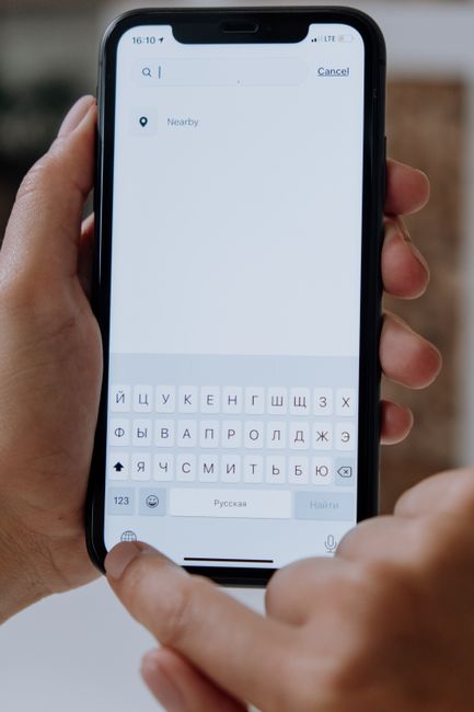 Close-up of hands holding a smartphone with a digital search interface.