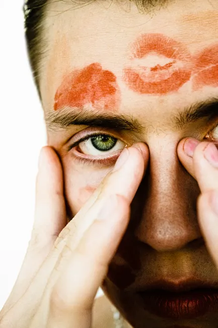 Close-up portrait of a person with lipstick marks, creating a unique artistic expression.