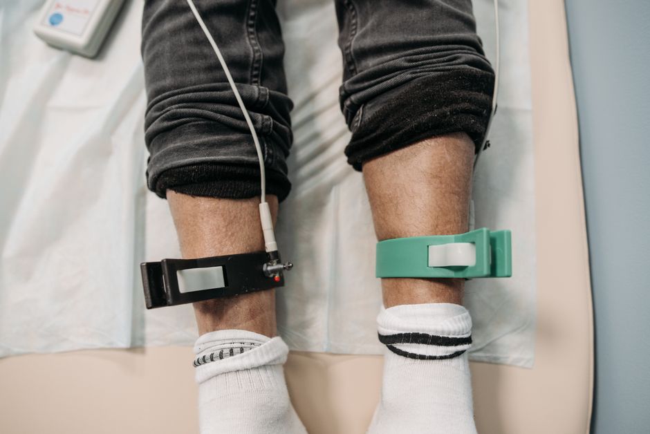 Close-up view of medical electrodes on a patient's lower legs during a medical procedure in a clinic.