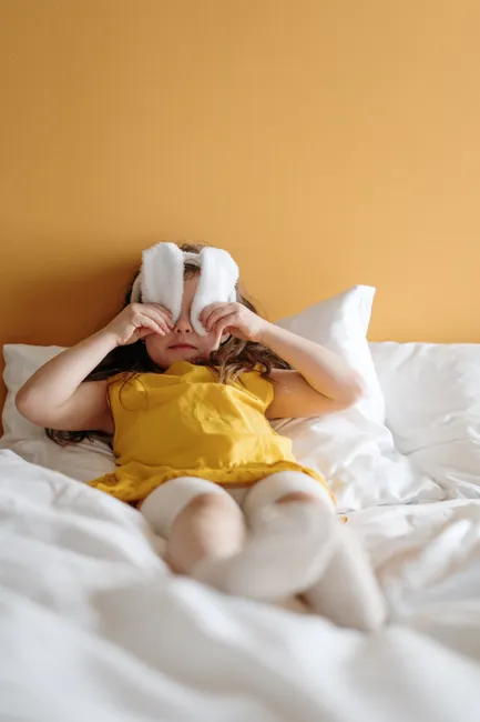 Cute child with bunny ears enjoying springtime fun indoors on a sunny day.