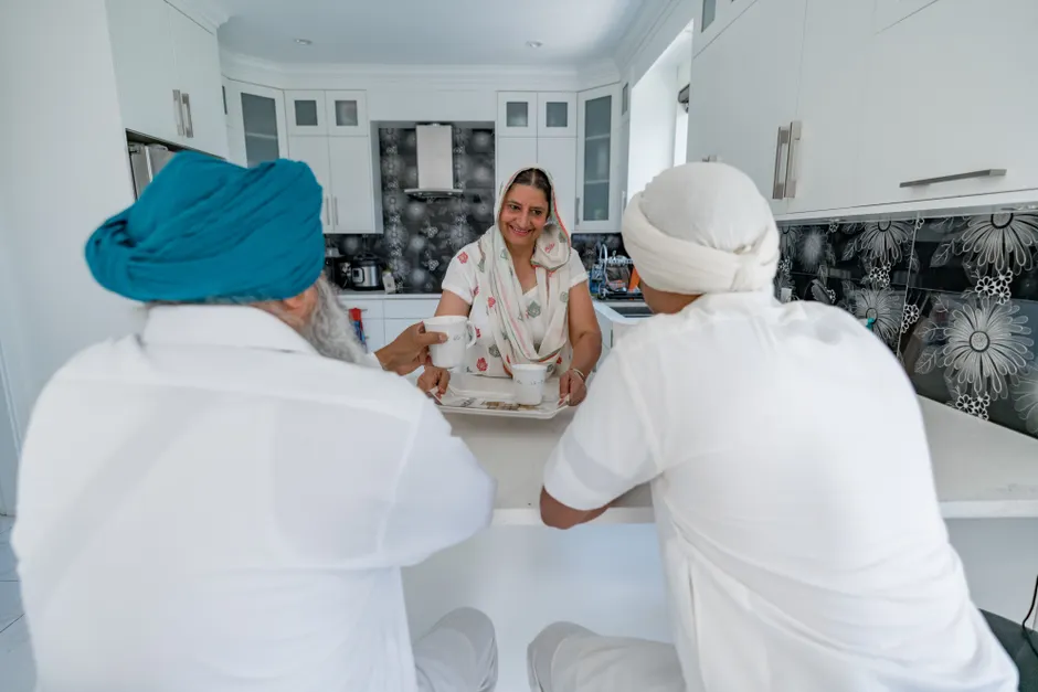 Family members engaging in conversation at a modern kitchen counter indoors.