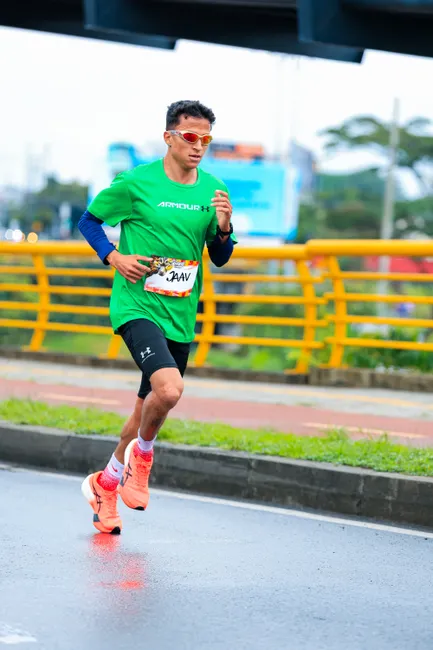 Focused runner in green shirt participates in city marathon, embodying athleticism and determination.