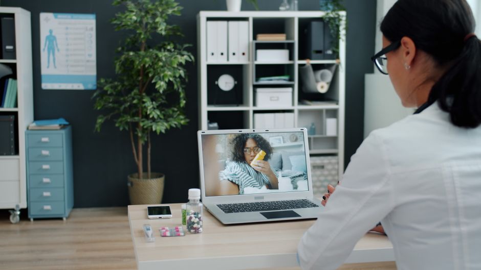 Healthcare professional having virtual appointment with patient on laptop.