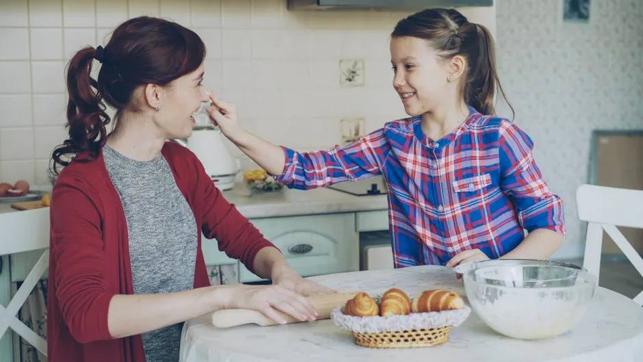 Nature ou culture? Ce que la psychologie sait de nos différences Joyful mother and daughter baking at home, sharing a fun and intimate moment.