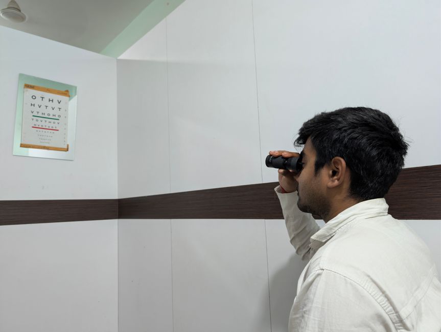Man having an eye test using an eye chart in an optometry clinic.