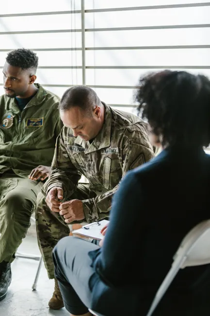 Military personnel in a group therapy session, focusing on mental health support.