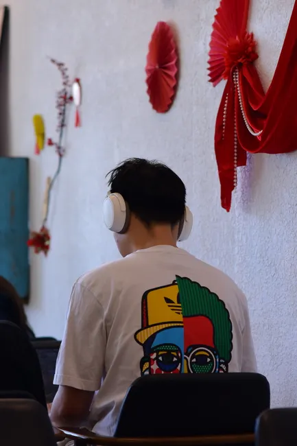 Person wearing headphones in a creatively decorated room with red accents.