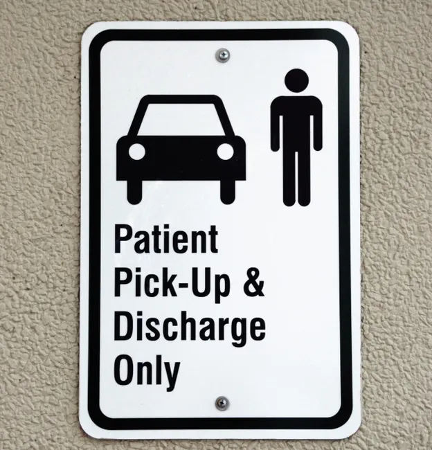 Sign indicating patient pick-up and discharge area at a healthcare facility.