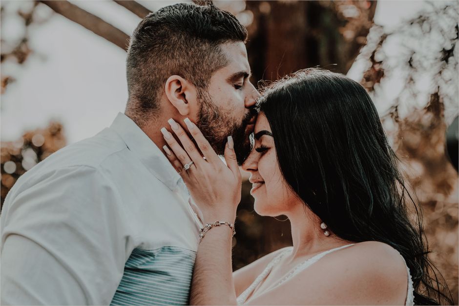 Pourquoi embrasse-t-on? Le baiser entre attachement, désir et culture Tender moment of a couple sharing a forehead kiss outdoors, capturing love and serenity.