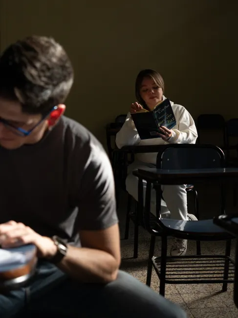 Two students engaged in reading and note-taking in a quiet Buenos Aires classroom.