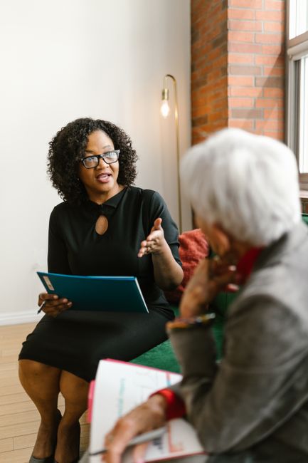Two women engaged in a professional meeting, discussing business in a modern office setting.