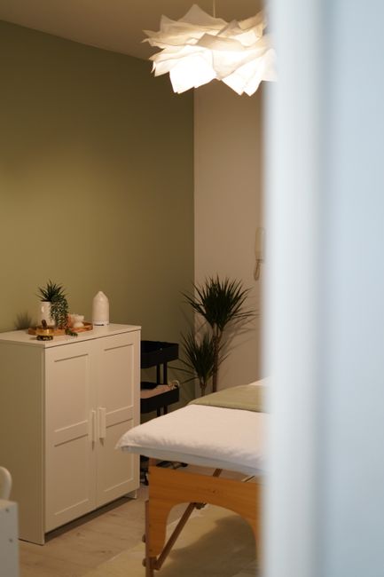 Warm and inviting spa room interior with soft lighting, green walls, and elegant decor.