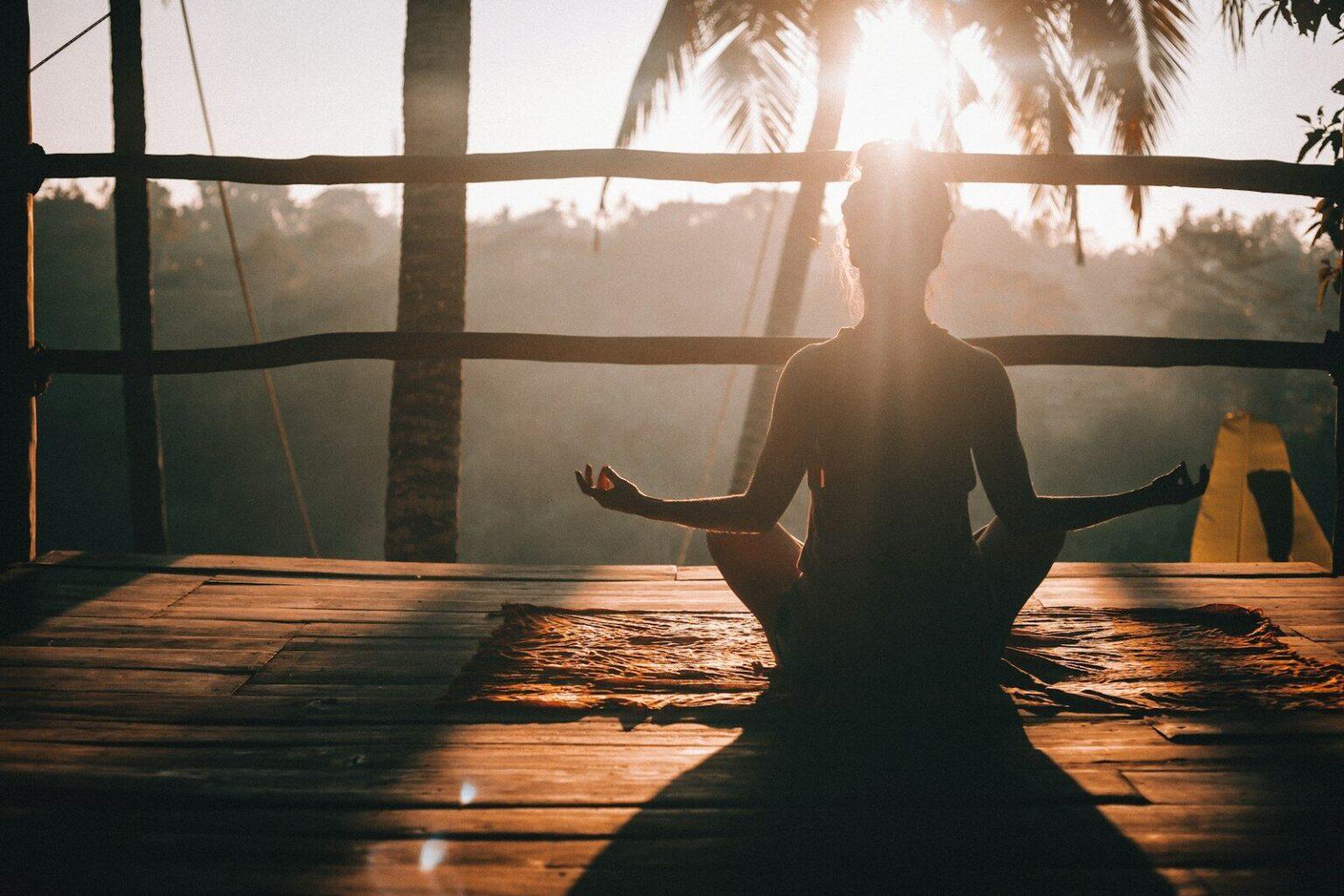 Formation Yoga 200h : Votre Passeport vers une Certification d’État woman in black tank top sitting on brown wooden dock during daytime