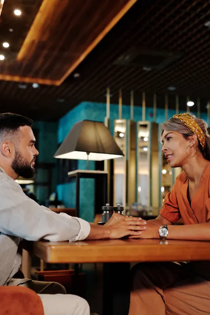 A couple enjoys a romantic date in a stylish indoor restaurant setting, chatting and connecting.