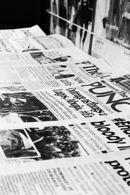 A detailed close-up of Nigerian newspapers in a monochrome format showcasing headlines and articles.