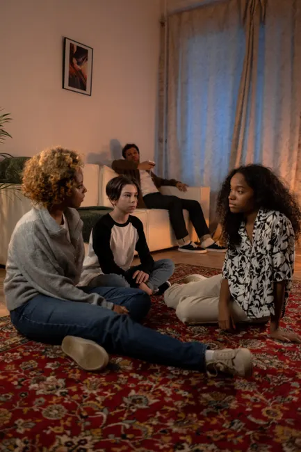 A diverse family engaged in a serious discussion in their cozy living room.