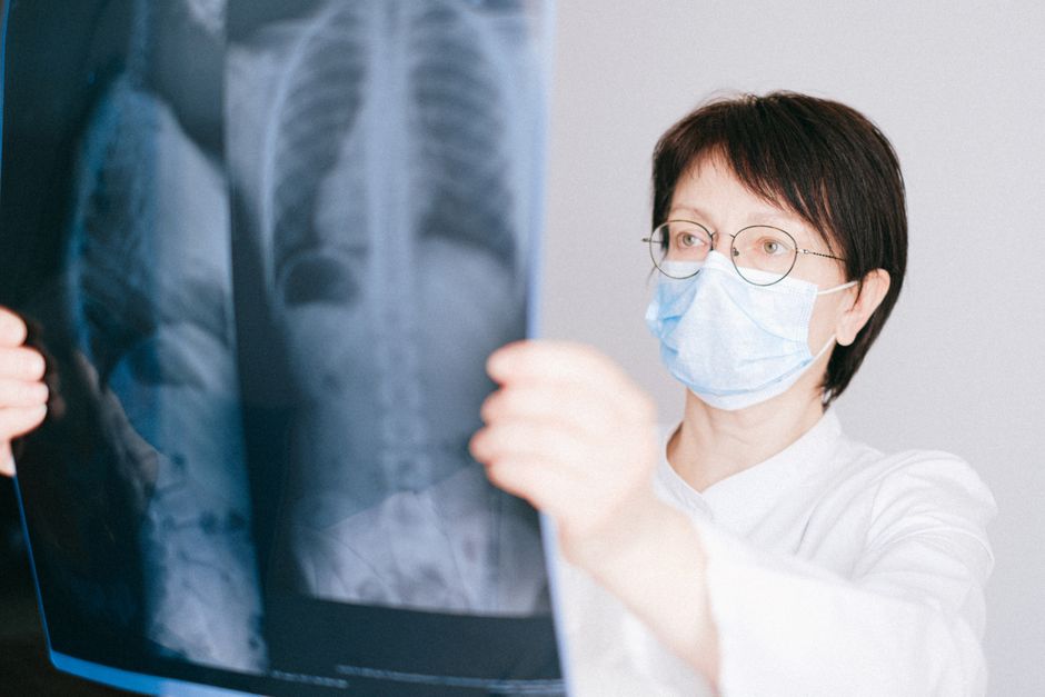 A doctor examines a chest X-ray in a clinical setting, highlighting medical diagnostics.