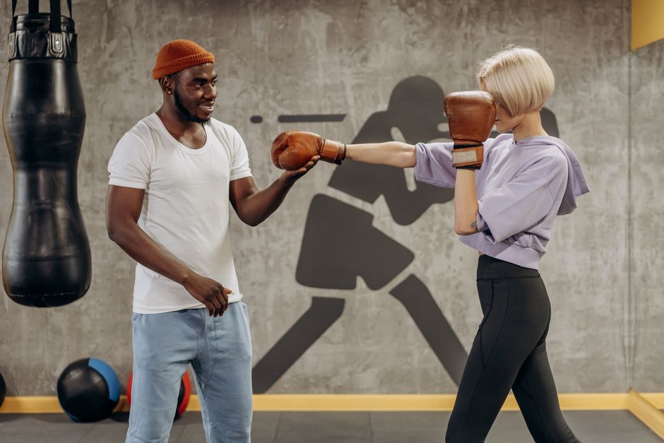 Respiration carrée : méthode, effets mesurés et limites du box breathing A female athlete spars with her coach in a gym, practicing boxing techniques indoors.