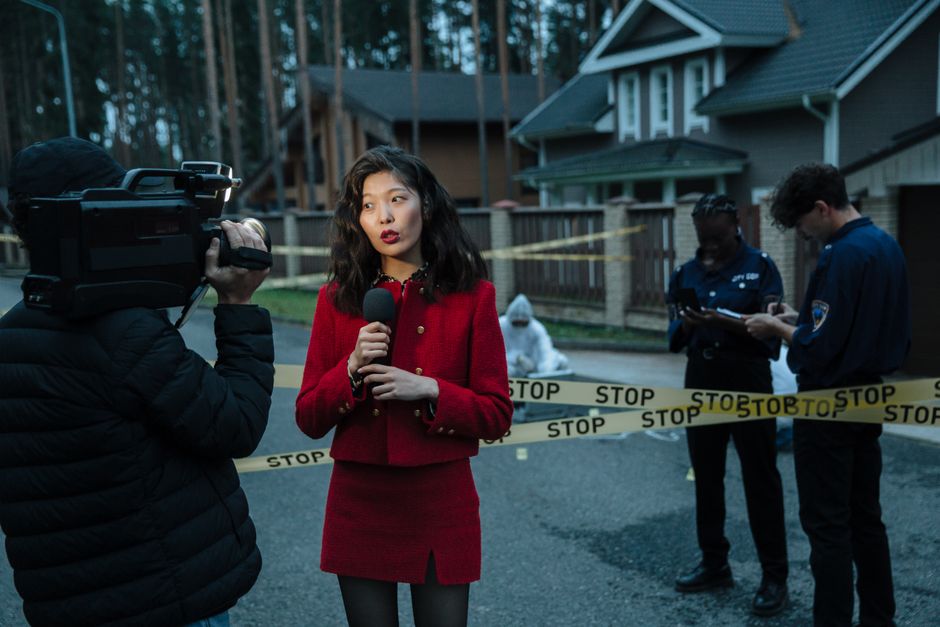 Quand les médias racontent les troubles mentaux, les mots ne restent pas à l’écran A journalist reporting from a crime scene with police officers and cameraman.