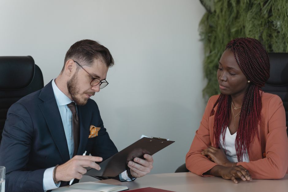 A man and woman engaging in a job interview in a modern office setting.