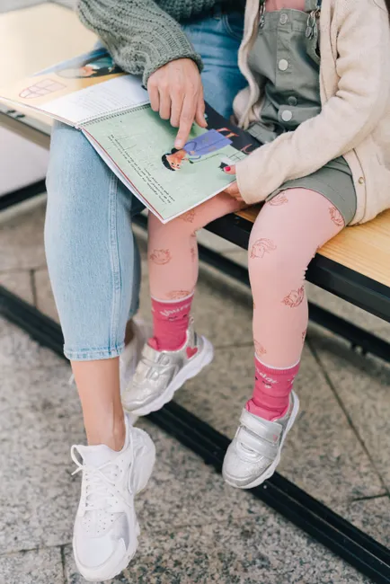A mother and child engaging in reading a children's book, fostering learning and bonding.