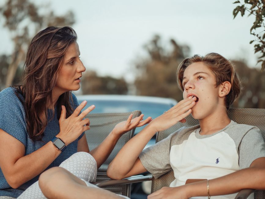 Facteurs de risque des troubles alimentaires : ce que les études permettent vraiment de dire A mother and her teenage son are having a conversation outdoors. The son appears disinterested.