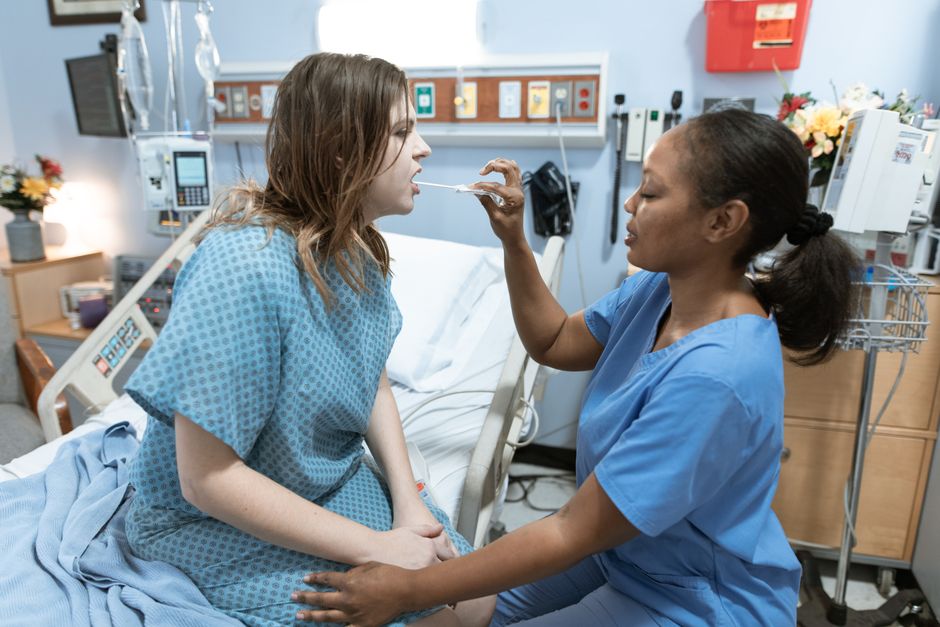 A nurse in scrubs caring for a patient in a hospital ward, demonstrating healthcare services.