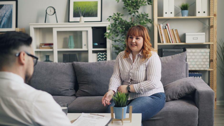 A therapist and client engage in a discussion in a modern office setting, emphasizing mental health support.
