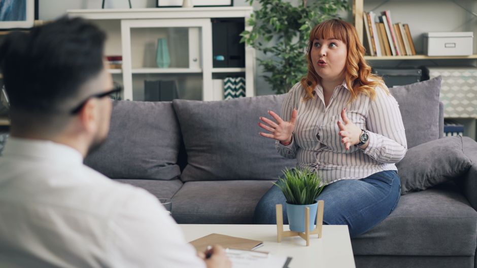 A therapy session in progress with a therapist and a patient discussing indoors.