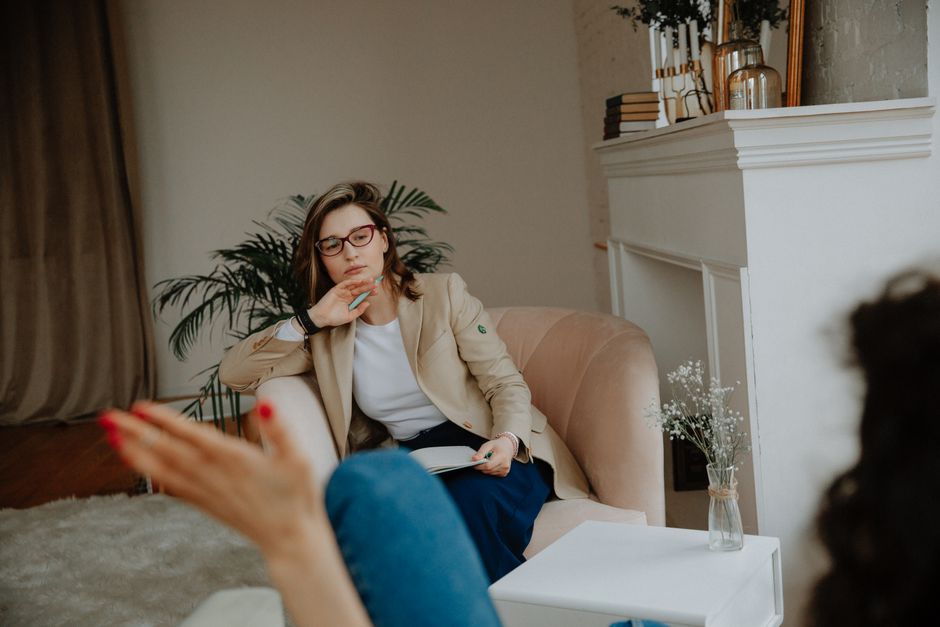 Travail du sexe et santé mentale : quand la stigmatisation dégrade le soin A woman counselor attentively listens during a therapy session in a cozy office environment.