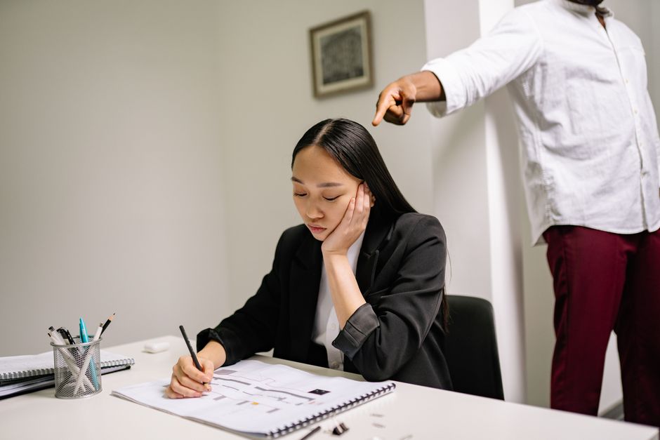 Harcèlement au travail : la personnalité sombre n’explique pas tout An unhappy employee experiencing workplace bullying, depicted by finger pointing in an office setting.