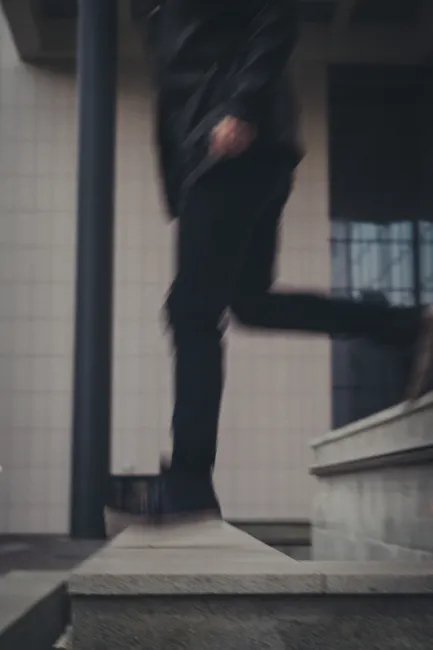 Blurred image of a person stepping down a city staircase.