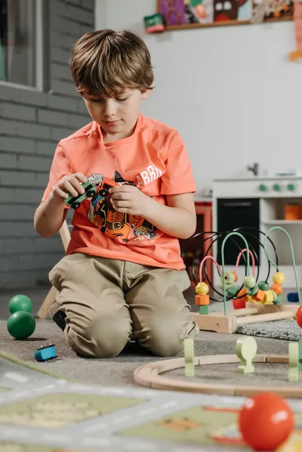 Child playing with colorful toys in a cozy indoor playroom setting.