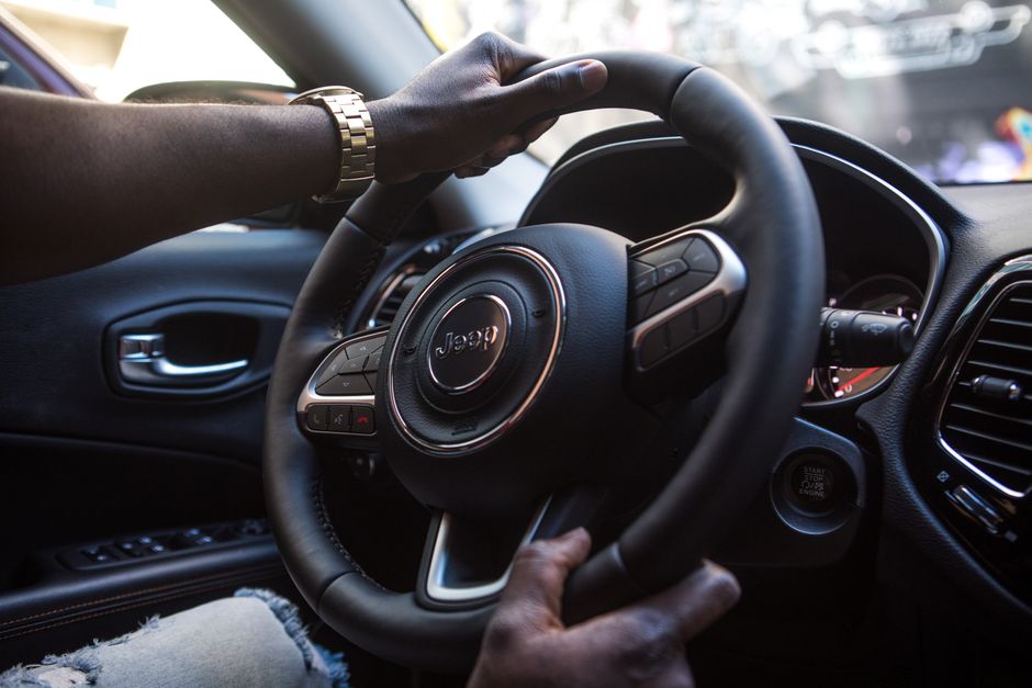 TDAH et conduite : risques, traitements et stratégies de sécurité Close-up of a man's hands on a luxury car steering wheel highlighting modern interior.