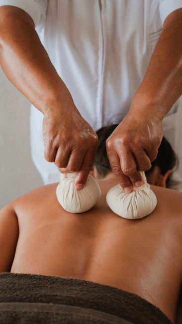 Close-up of a relaxing herbal compress massage in a serene setting.