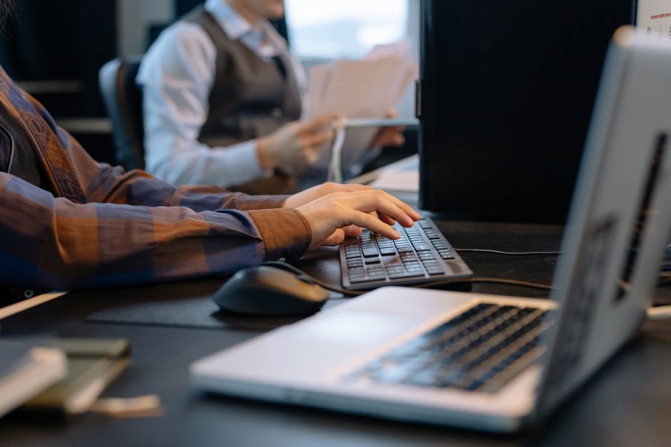Close-up of office workers engaged in a tech project at a modern workplace.