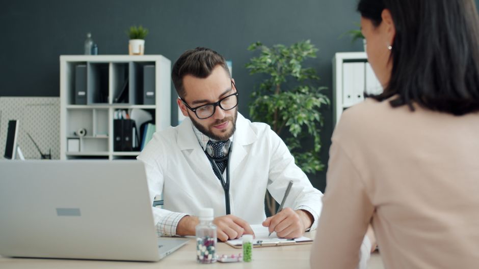 Épilepsie et dépression : pourquoi le suivi doit porter sur les deux Doctor in white coat consulting patient in a modern office setting.