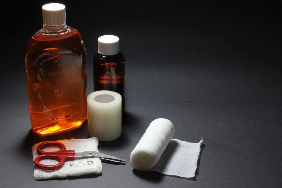 Surdosage d’antidépresseurs : les signes qui imposent d’agir First aid supplies including bandages, bottles, and scissors laid out on a dark surface.