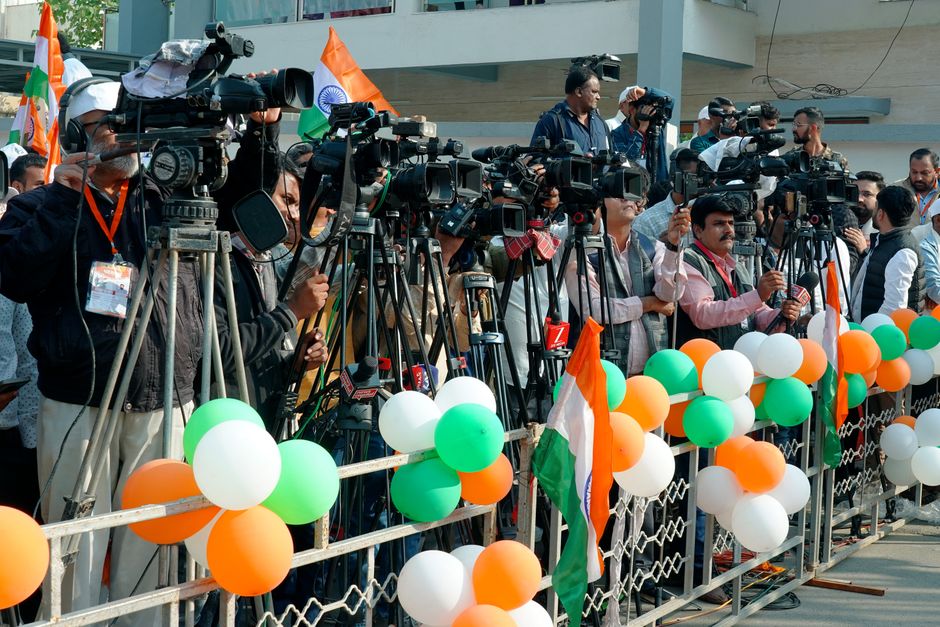 Journalists and videographers gather with cameras in Ahmedabad, capturing a vibrant scene.