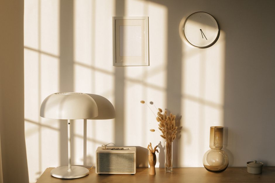 Luminothérapie et dépression : ce que montrent les études Light room with retro radio and decorative vases with dry plants on desk near wall with clock and window shadow in sunlight