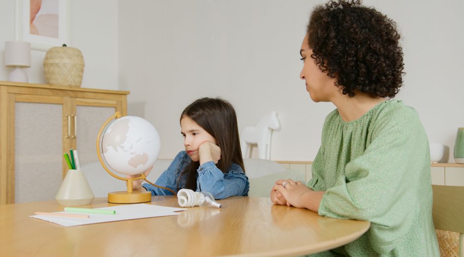 Teacher and student in discussion about globe and environment.