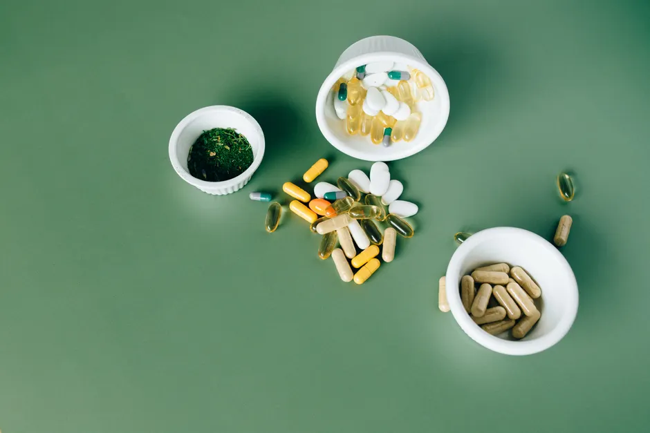 Probiotiques, anxiété et dépression : ce que montrent les méta-analyses et l’essai de 2026 Various herbal and vitamin pills and capsules on a green surface.