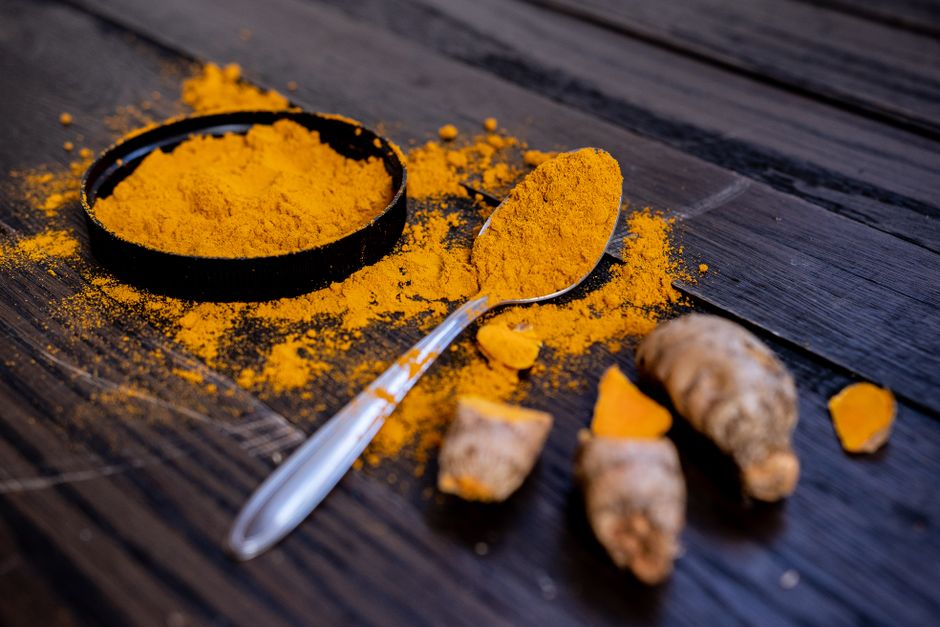 Curcuma et dépression : ce que les études montrent en 2025 Vibrant turmeric powder and root on a dark wooden surface, emphasizing natural spices.