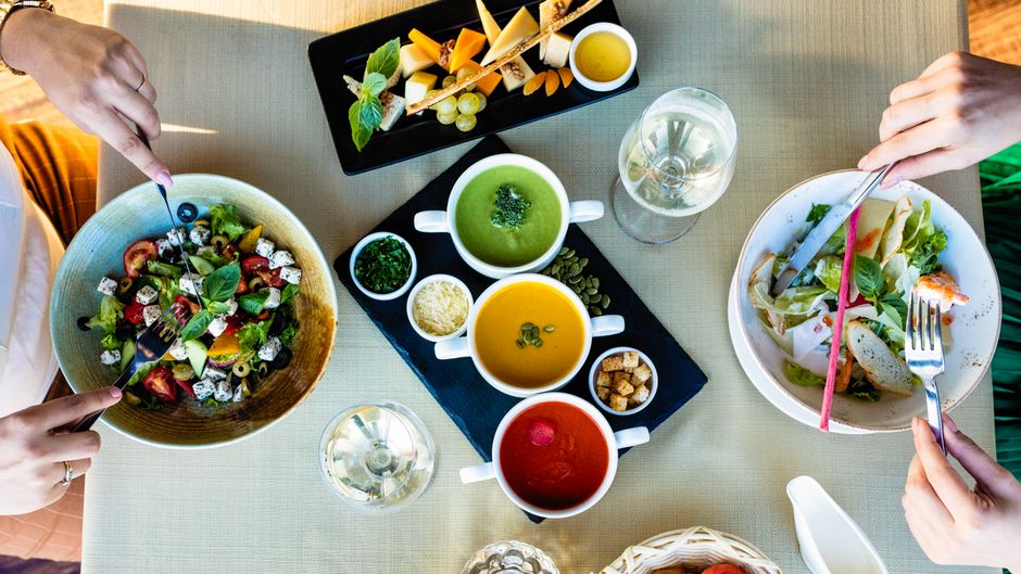 Vibrant vegetarian dining setting featuring assorted soups and fresh salads for a healthy meal.